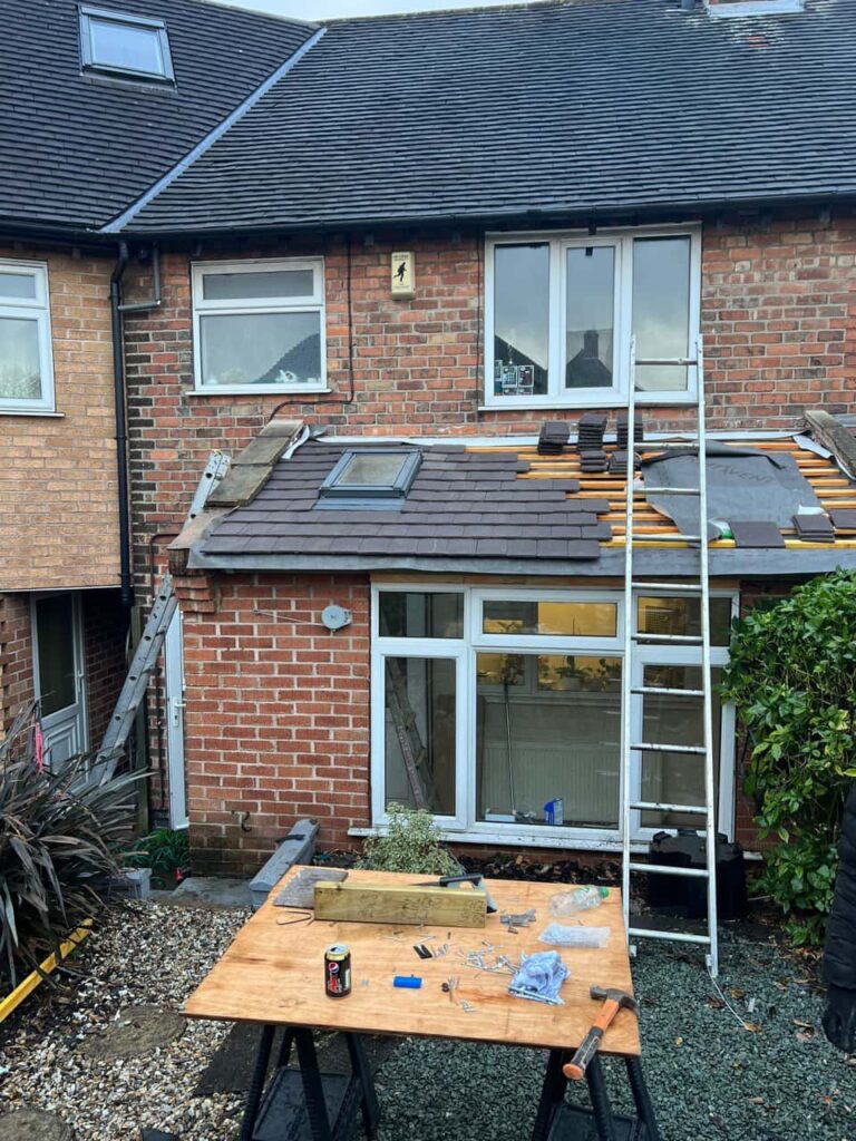 This is a photo of a roof extension that is having new roof tiles installed. This is a photo taken from the roof ridge looking down a tiled pitched roof on to a flat roof. Works carried out by Rainworth Roofing Repairs