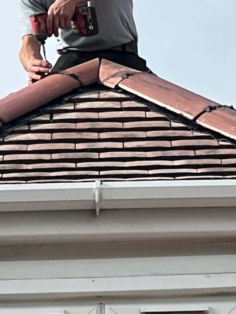 This is a photo of one of the operatives of Rainworth Roofing Repairs installing new ridge tiles