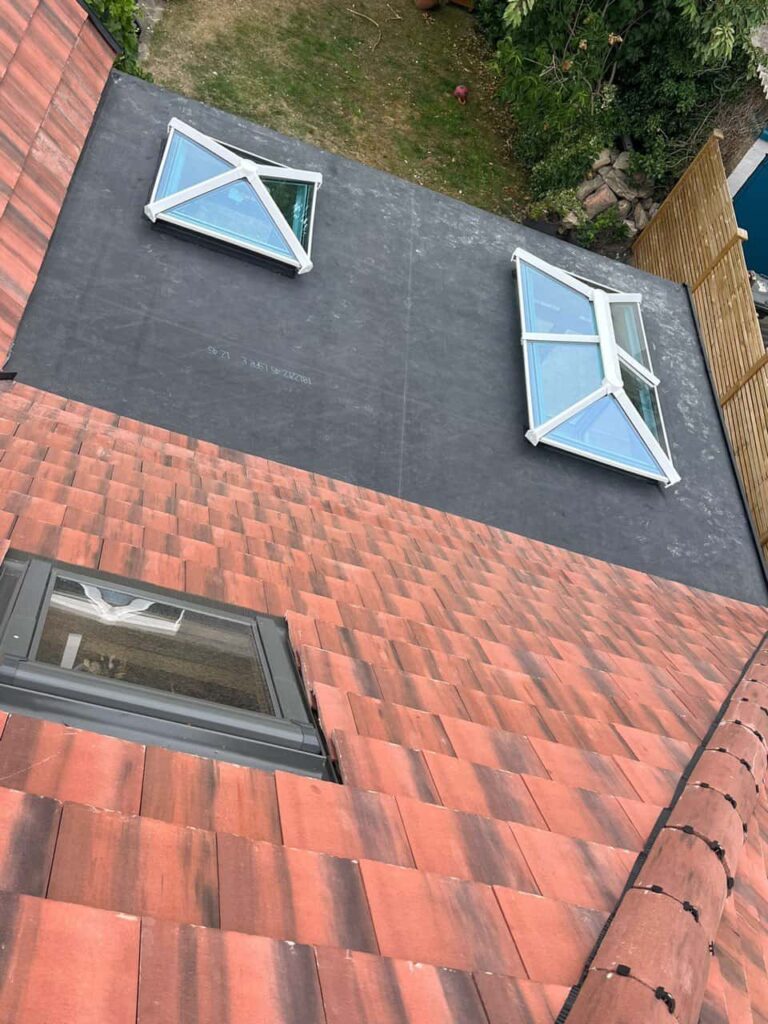 This is a photo taken from the roof ridge looking down a tiled pitched roof on to a flat roof. Works carried out by Rainworth Roofing Repairs